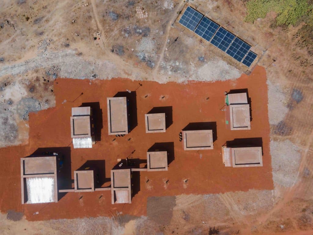 Vue aérienne d'une zone d'activité électrifiée au Mali, toitures équipées de panneaux solaires.