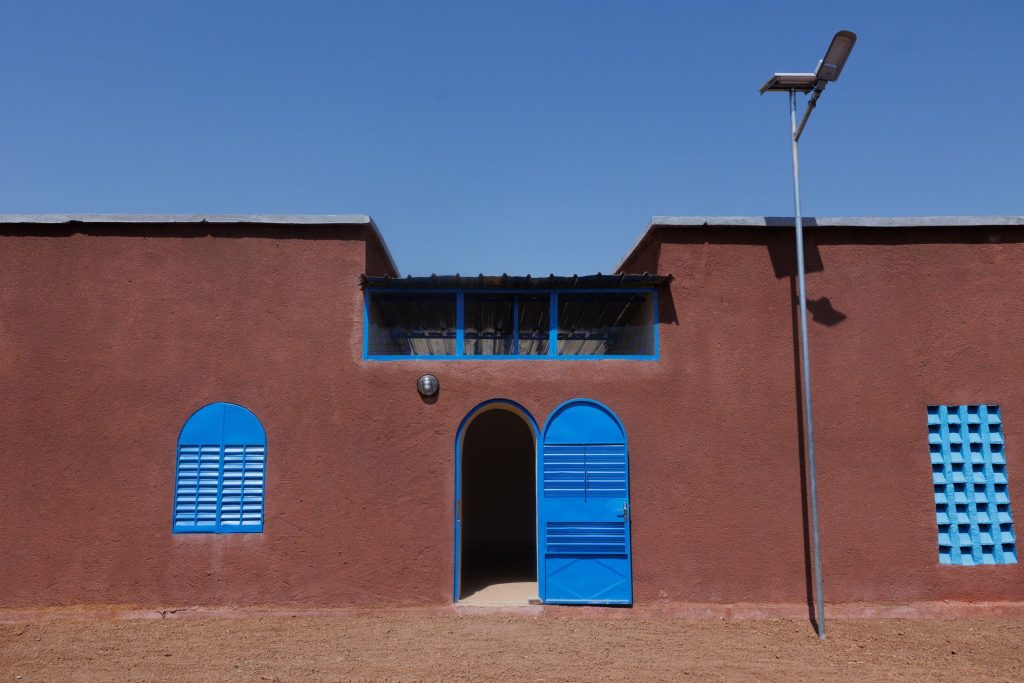 Boutique à façade bleue, zone d’activités électrifiée (Mali)